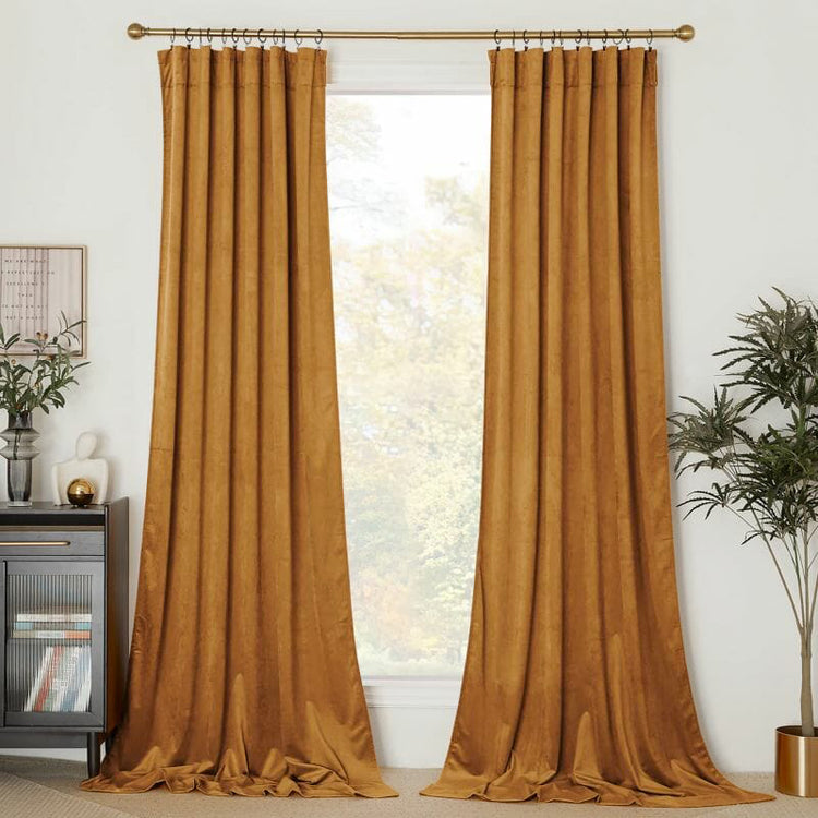 Luxurious amber velvet custom drapery, tailored pinch pleat style, floor-pooling for high-end window treatments.