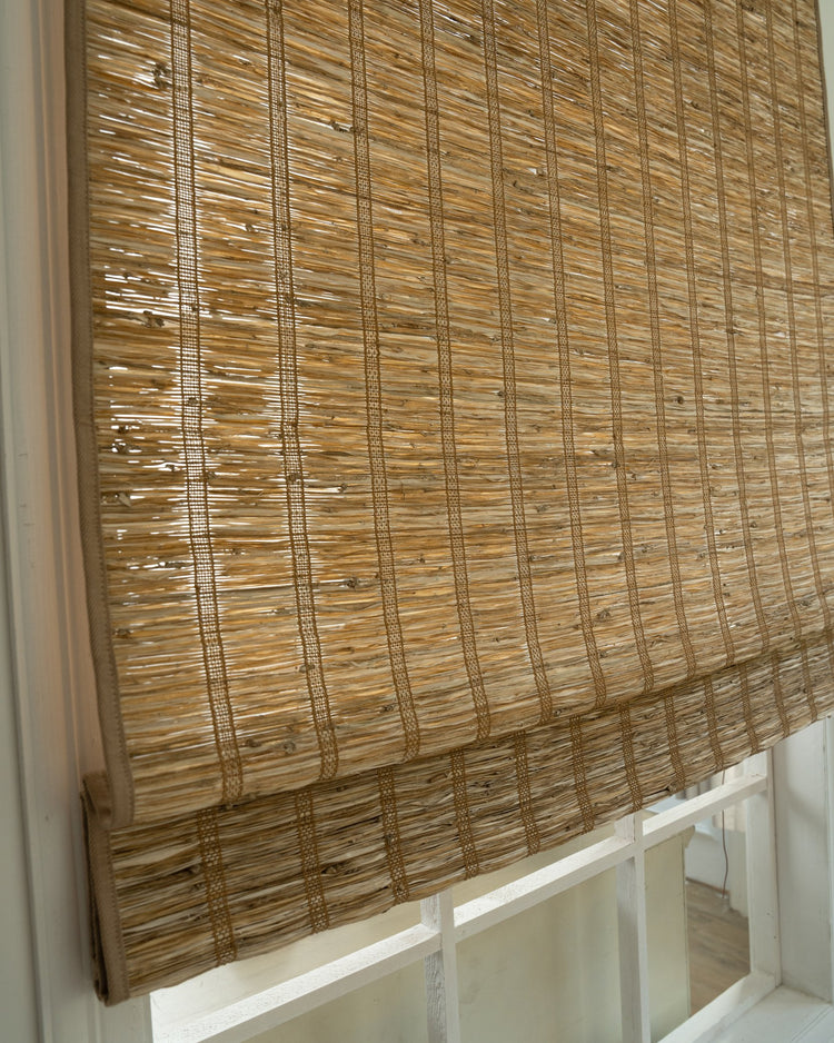 Rumi Hay jute woven window shade in a close-up, highlighting its natural texture, craftsmanship, and light-filtering design.