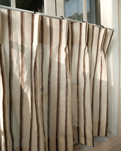 Sunlit close-up of Cate 100% linen custom cafe curtain, featuring elegant cream & brown stripes and tailored pleats.