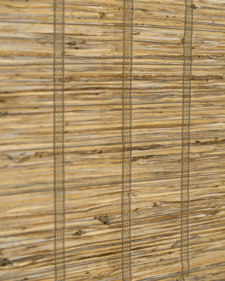 Detailed view of Rumi Jute Woven Shade in Straw, highlighting its raw natural texture and intricate vertical weaving for custom window treatments.