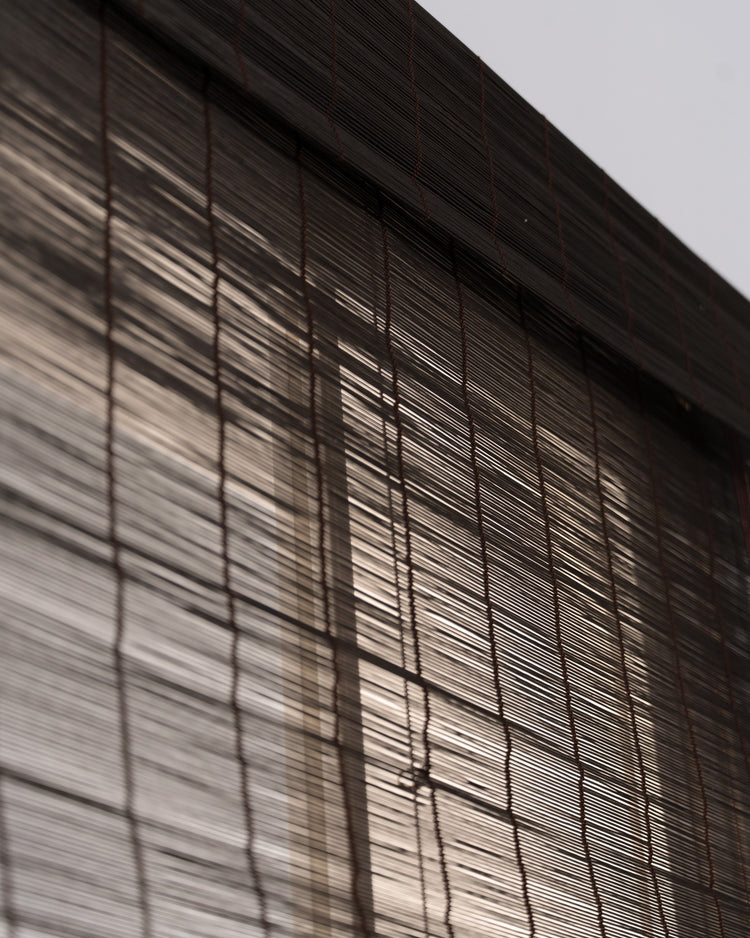 Toni Hazel Bamboo Woven Shade closeup, revealing natural dark brown texture and sunlight filtering through for balanced light control & privacy.