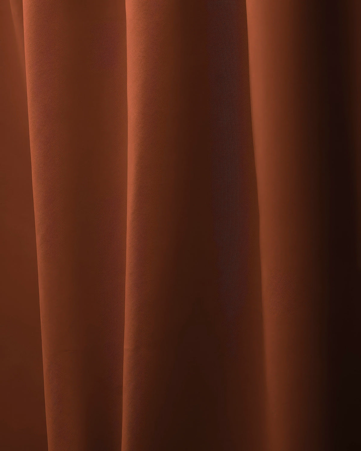 Close-up of Hussein OEKO Certified custom curtain in a luxurious deep rust color, revealing its refined weave and graceful fabric folds.