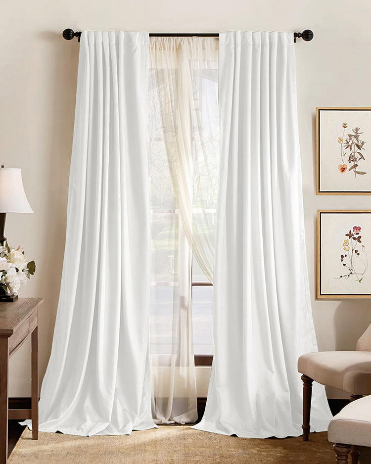 Sophisticated white custom blackout curtains with a pleated header, layered over sheer panels, offering elegant light control and privacy.