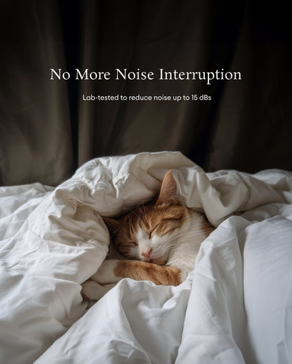 Orange and white cat sleeping soundly under white blankets, emphasizing the quiet comfort of soundproof blackout custom curtains.