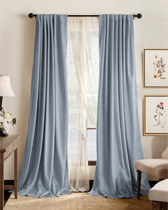 Light blue premium 4-layer custom blackout curtains, soundproof & thermal, with rod pocket header in a room.