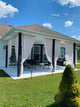 Custom white canvas waterproof outdoor curtains on a modern patio, tied back, providing elegant privacy and light control.