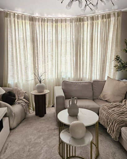 Elegant Jupiter Linen Look Soft Heavyweight Sheer Custom Curtains on a curved window, enhancing a modern living room's sophisticated aesthetic.