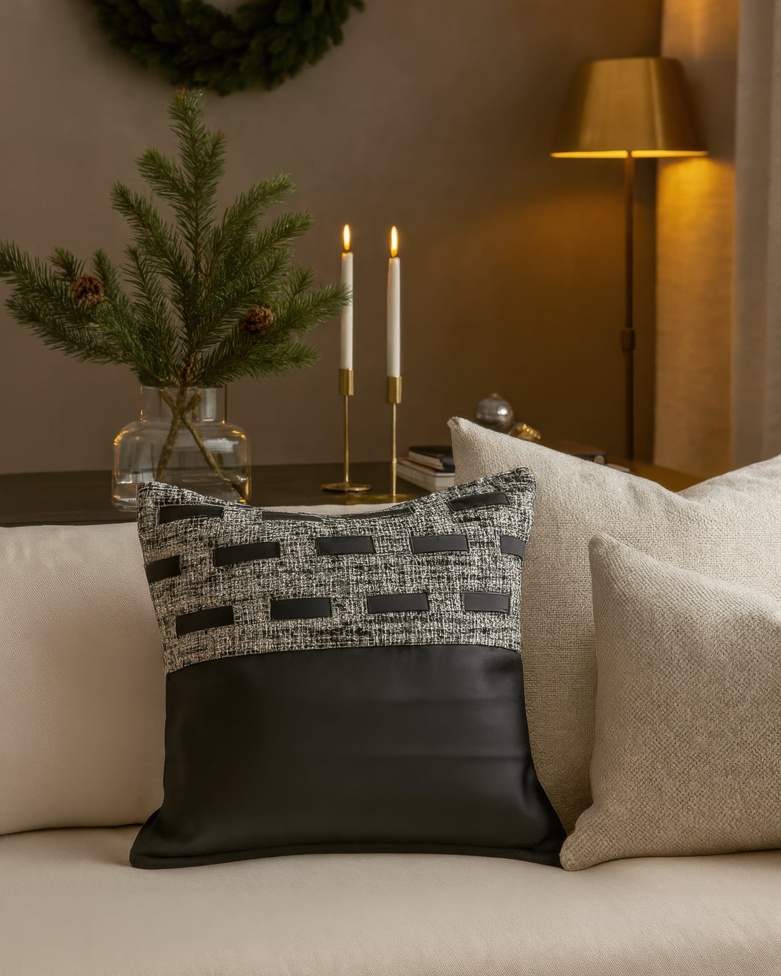Juliette textured faux leather throw pillowcase in black & gray with modern strip accents, styled on a light sofa.
