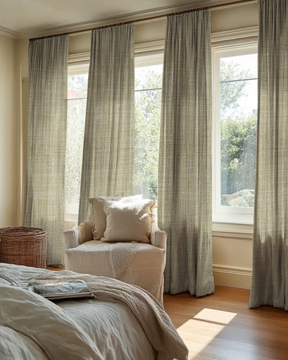 Soft Jupiter linen look sheer custom drapery on three windows in a sunlit bedroom. Natural textured fabric offers elegant light control & privacy.