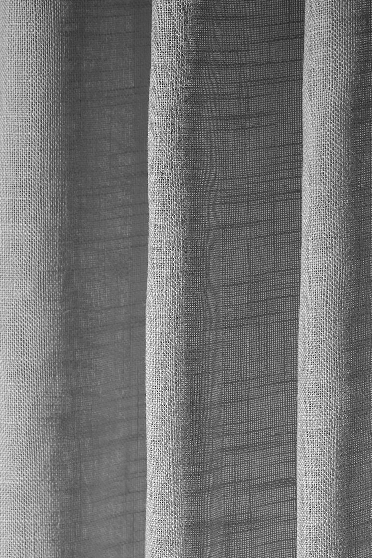 Detailed close-up of Tehreem Textured Sheer Custom Curtain fabric, highlighting the woven texture and soft, light-filtering drapery.