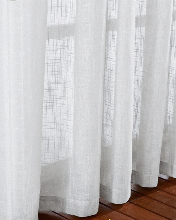 White Tehreem textured sheer custom curtains, showcasing delicate woven fabric detail & subtle light diffusion over a wood floor.