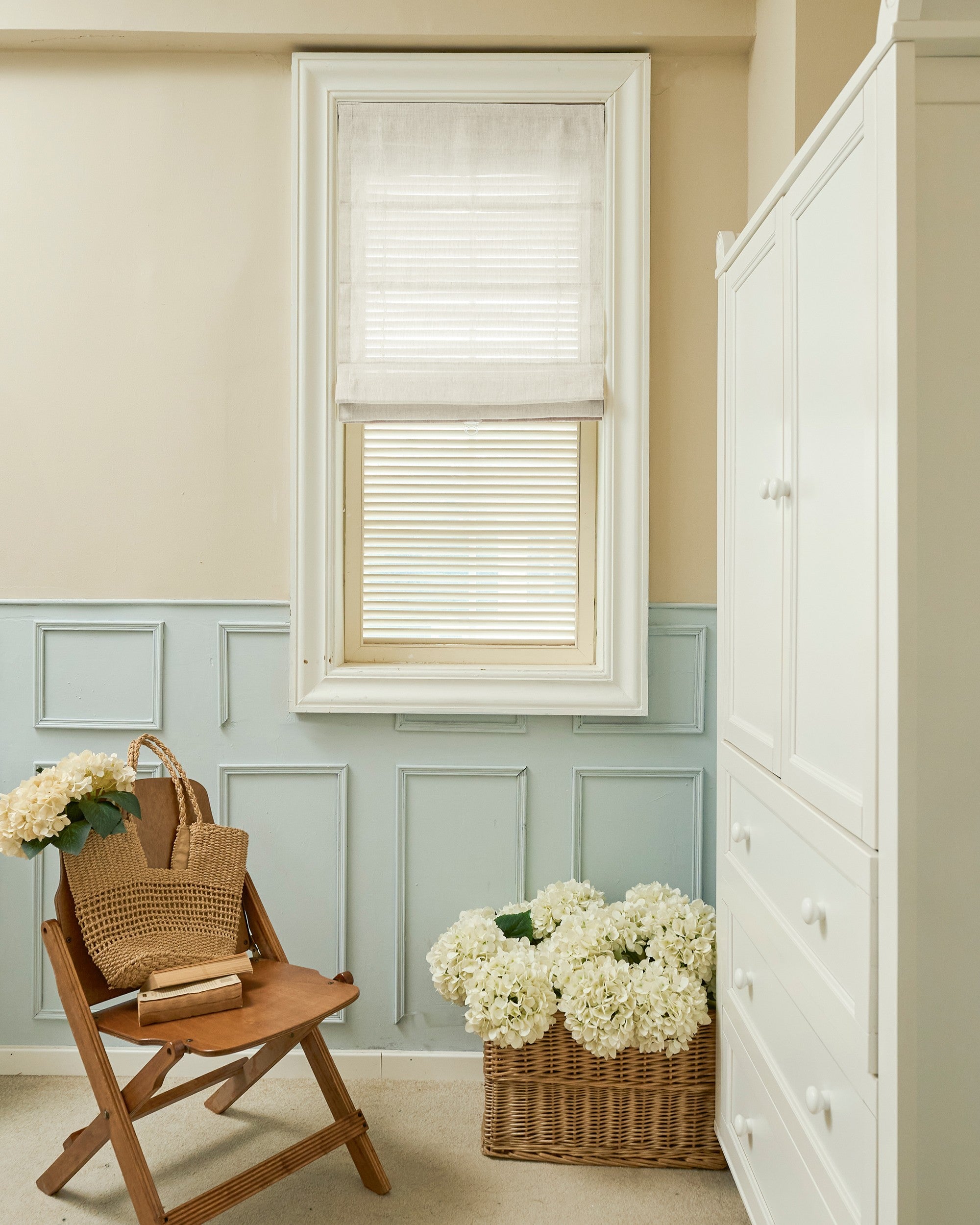 Custom Thistle sheer Roman shade with a sleek flat fold, offering light filtering in a classic room with blue wainscoting and decor.