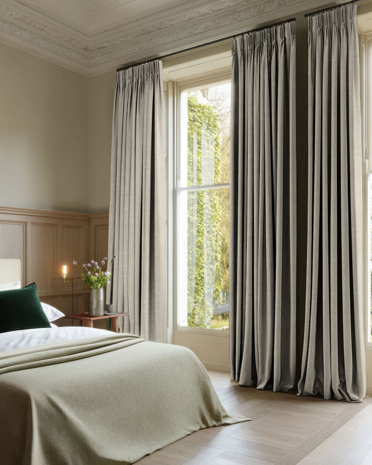 Bedroom with stylish grey 100% blackout jacquard custom curtains, featuring pinch pleat header for elegant light control and privacy.