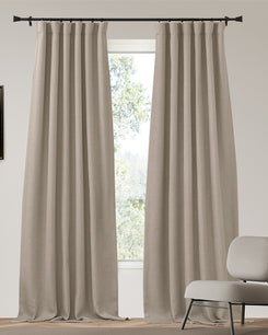 Beige linen-look custom blackout curtains with neat pleats on a black rod. Heavyweight 4-layer soundproof thermal drapery for privacy.