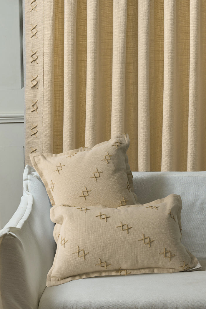 Arden Textured Yarn Stitched Lumbar Pillowcases, 'X' pattern, on white sofa; matching detail on custom beige drapery.