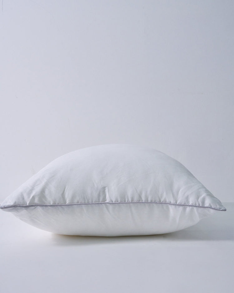 Plump white feather throw pillow insert with a soft texture and subtle piped edge, ready for a decorative cover.
