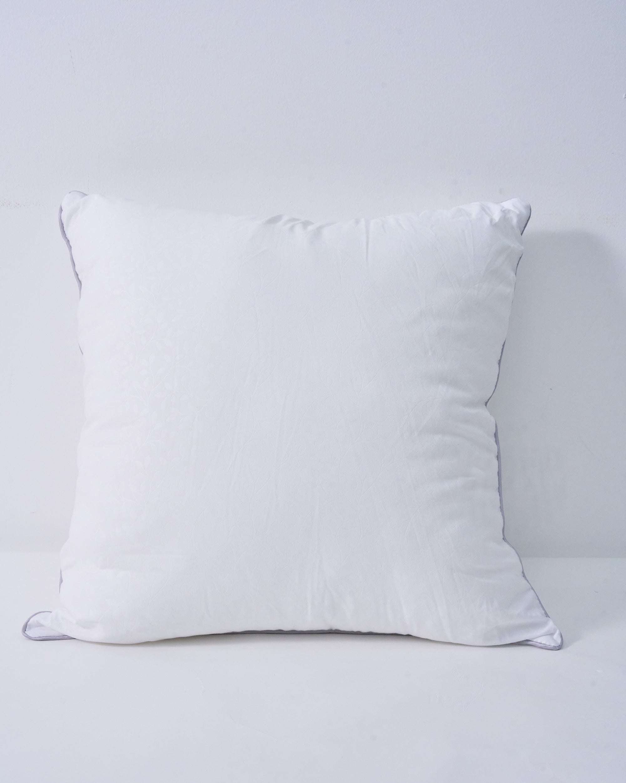Plush white feather throw pillow insert with subtle leaf pattern and grey piping, for a supportive, naturally full look.