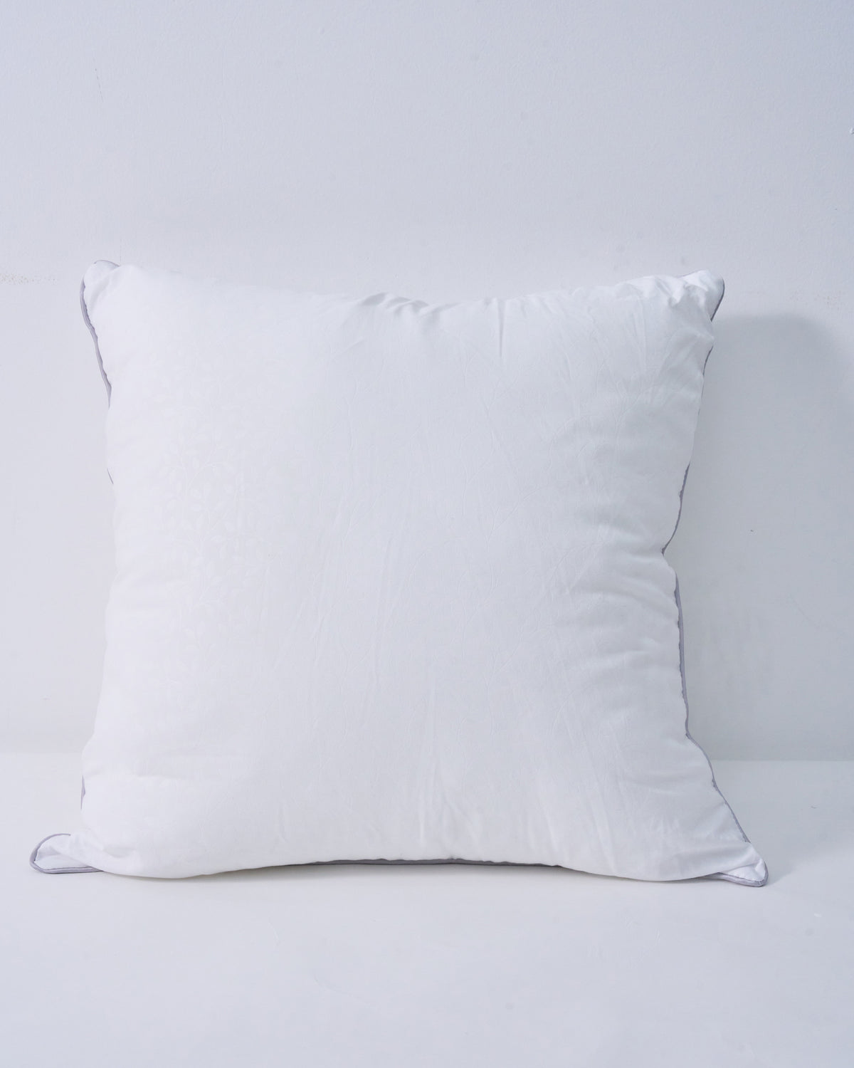 Plush white feather throw pillow insert with subtle leaf pattern and grey piping, for a supportive, naturally full look.