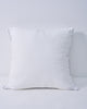 Plush white feather throw pillow insert, supportive and naturally full, with subtle leaf pattern and gray piping.