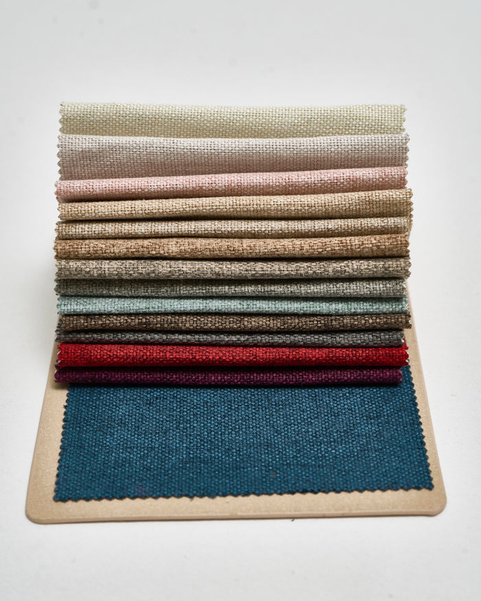 Victoria 100% blackout swatch book with 14 textured fabric samples in cream, grey, red, and teal for custom curtains.