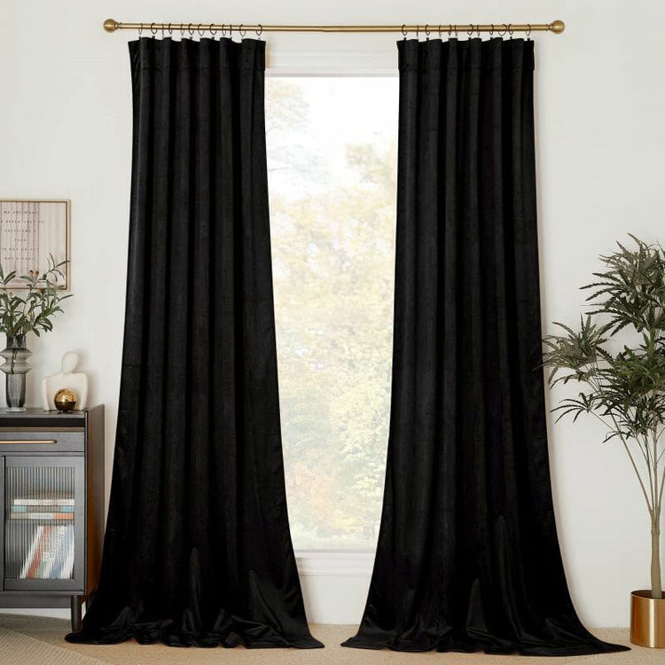 Luxurious black velvet custom drapery on a gold rod, floor-length, providing elegant window treatments and light control.