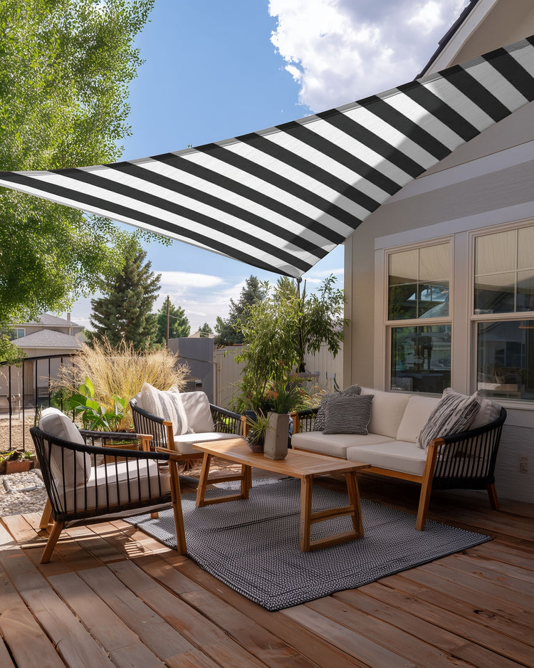 Black and white striped custom triangle sun shade sail covering a stylish outdoor deck with modern furniture.