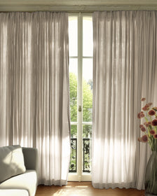 Custom Cassie linen blend curtains draped on a tall window, sunlight filtering through, offering elegant privacy & airy home decor.