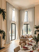Cream Cassie linen blend custom grommet curtains on extra-tall windows in an elegant, festive living room setting.