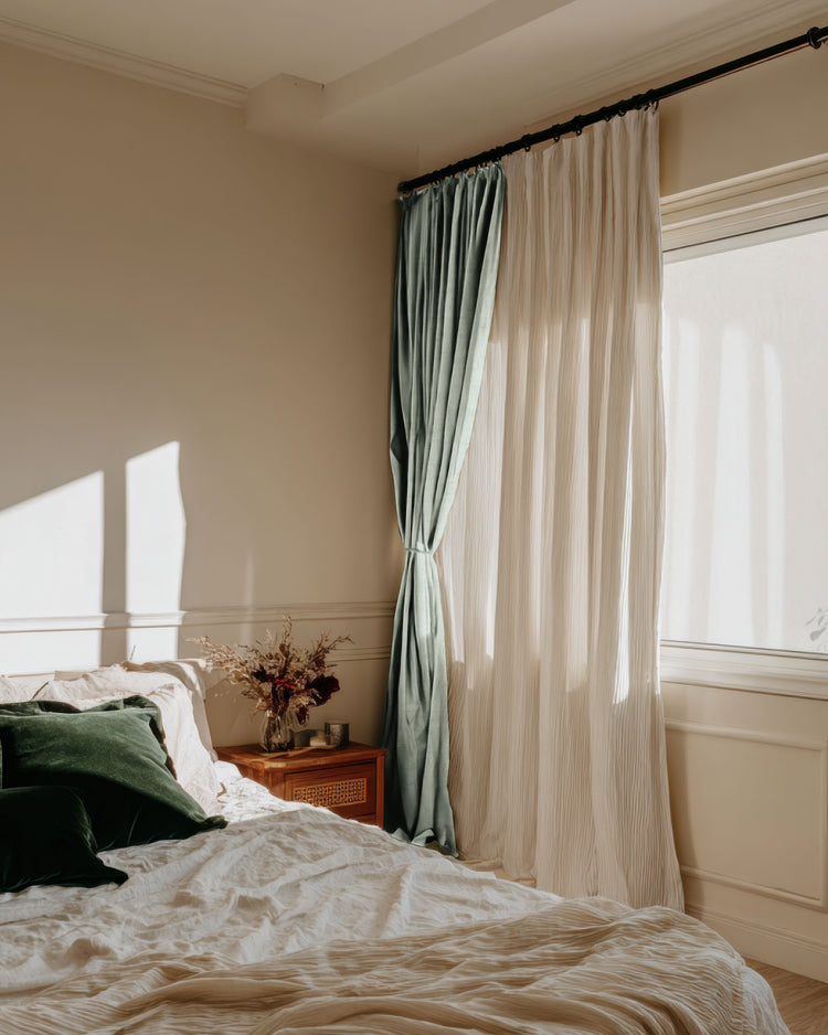 Chloe blackout linen look burlap textured curtain with tied-back velvet drape, enhancing sunlit bedroom's elegant aesthetic.