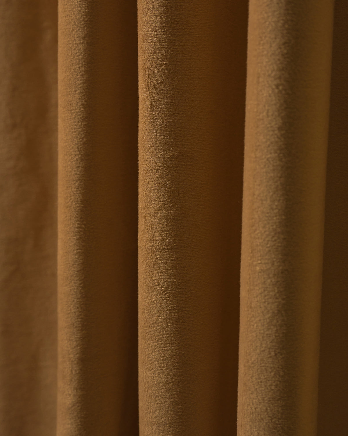 Close-up of rich brown velvet custom blackout curtain fabric, showcasing heavyweight texture and deep folds.