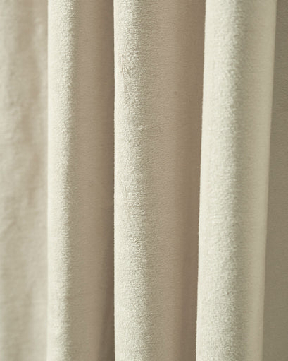 Close-up of luxurious, heavyweight beige velvet custom blackout curtain fabric, revealing its plush texture and soft folds.