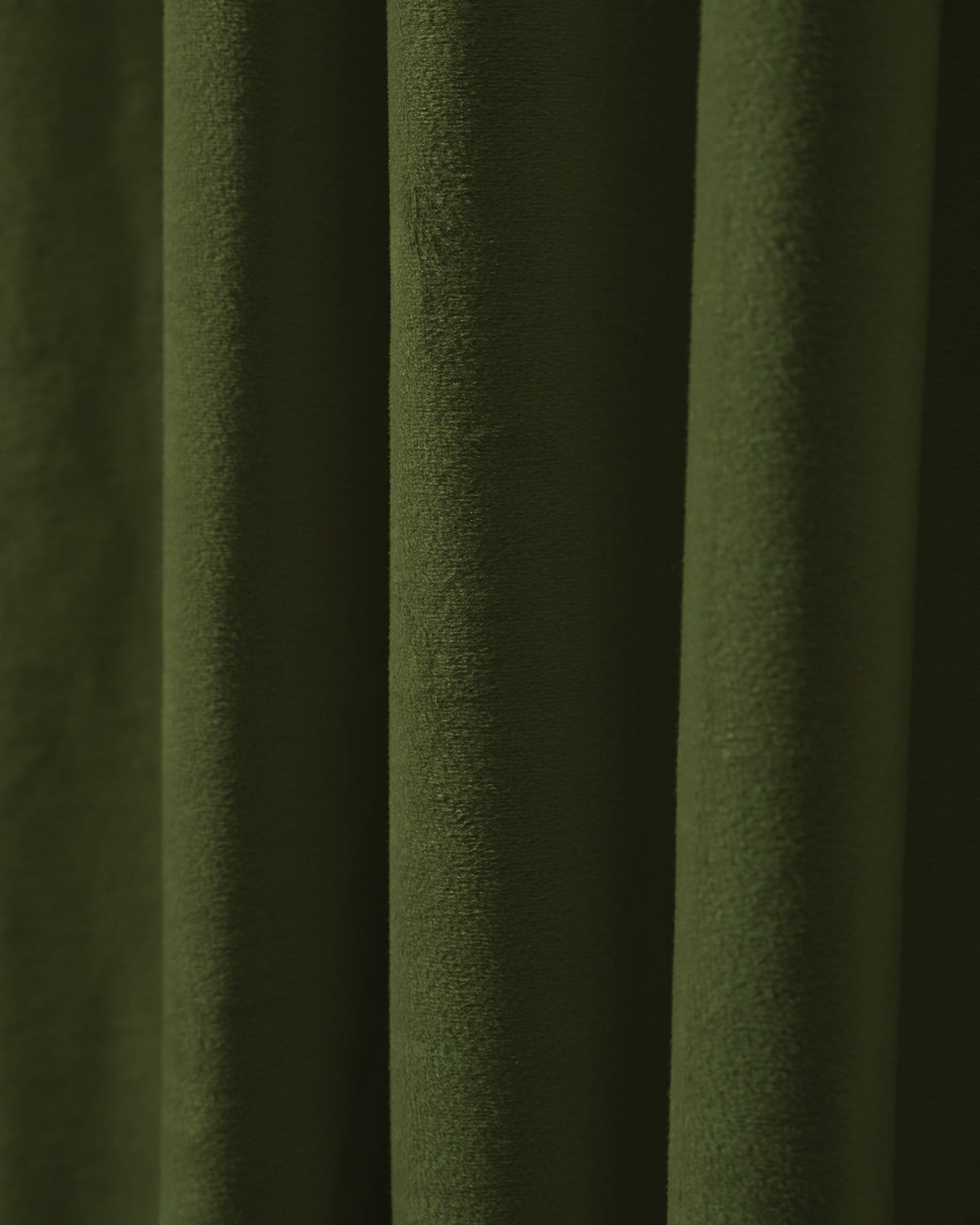 Close-up of deep green velvet custom blackout curtain fabric, showing its plush texture and elegant folds for luxury window treatments.