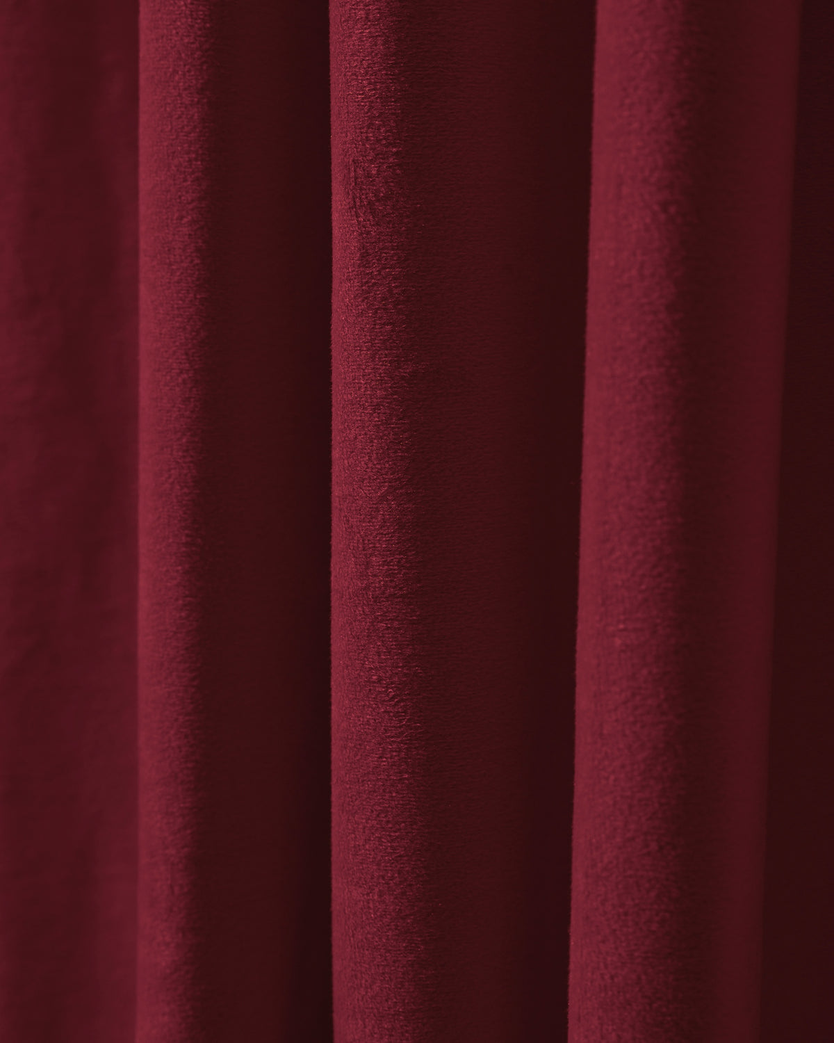 Plush, dark red velvet custom blackout curtain detail, highlighting its rich texture, ideal for soundproof and thermal insulation.