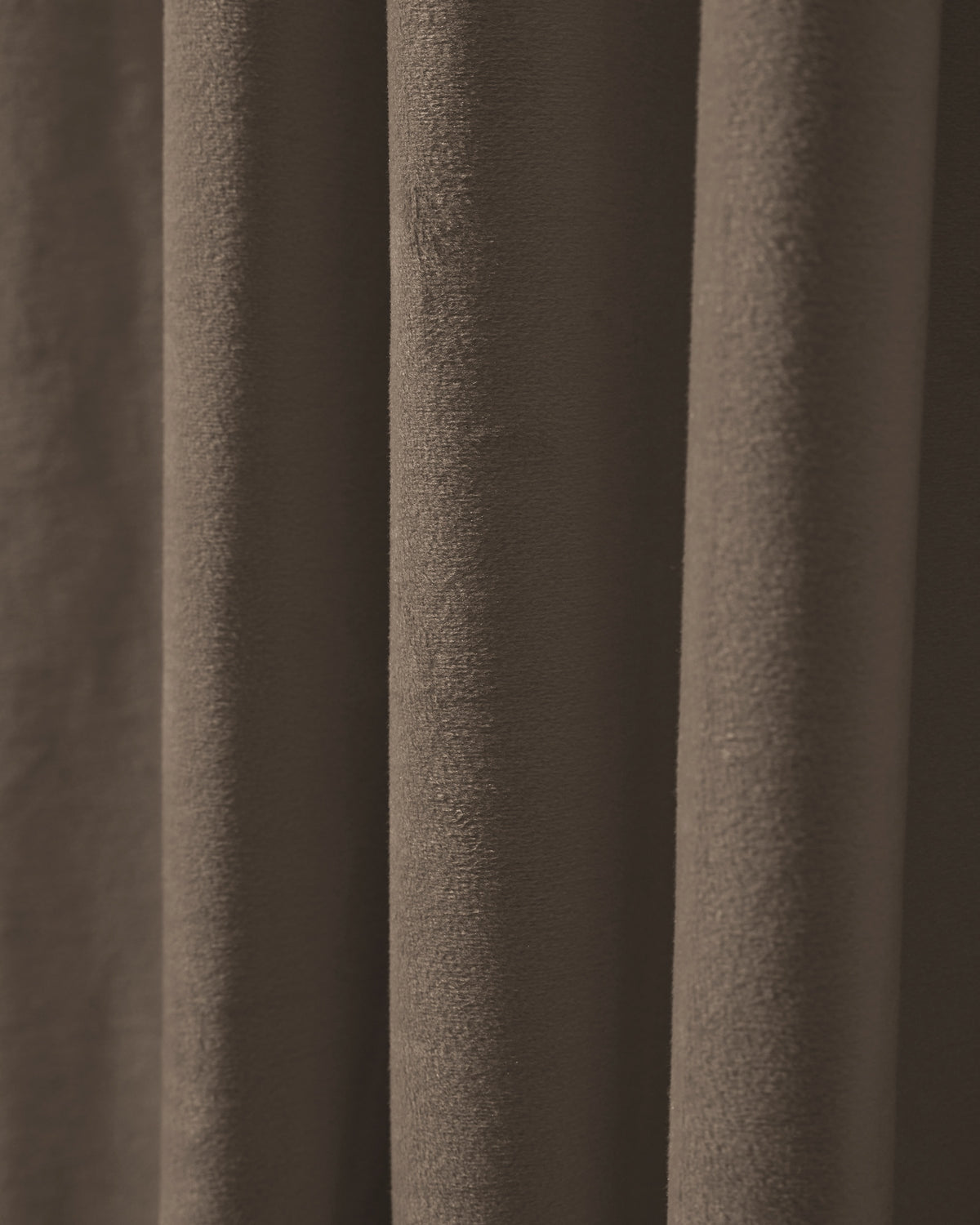 Close-up showing the rich, deep brown texture of a heavyweight velvet custom blackout curtain with elegant pleats.