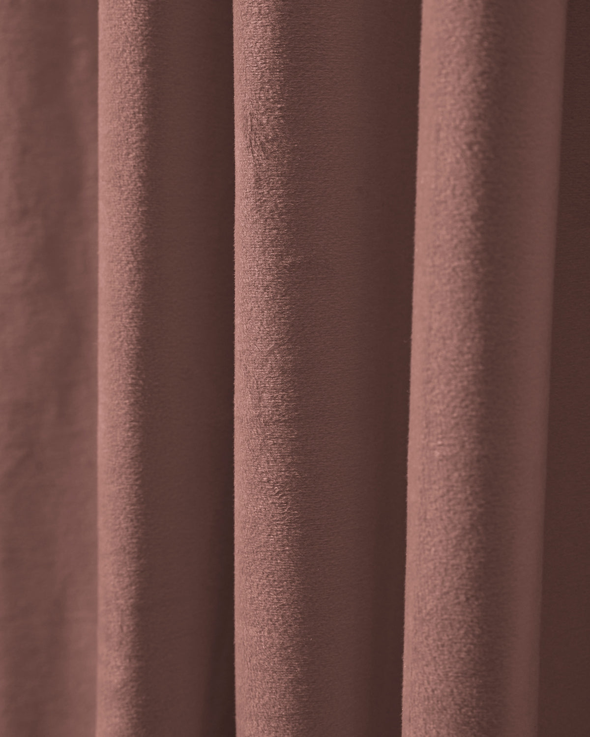 Close-up of plush, heavyweight velvet custom curtain fabric in muted rose brown, featuring elegant folds for optimal privacy & blackout.