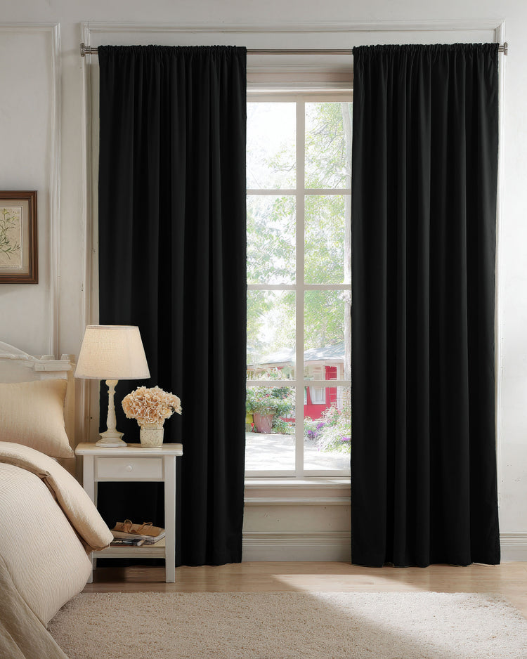 Elegant black velvet 100% blackout custom curtains with gathered header style, installed in a bedroom for complete privacy.