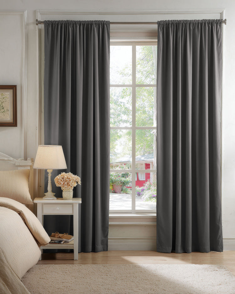 Sophisticated charcoal velvet custom blackout curtains with a rod pocket header, providing elegant privacy & light control in a bedroom.