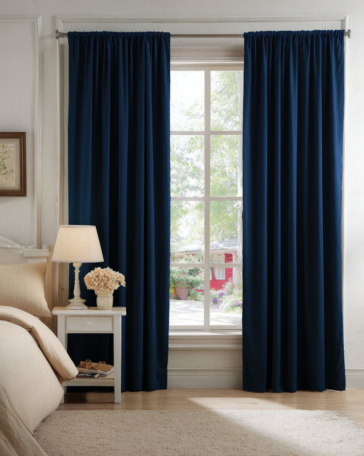 Navy velvet custom blackout curtains with a gathered header, framing a window in a serene bedroom, showcasing elegant light control.