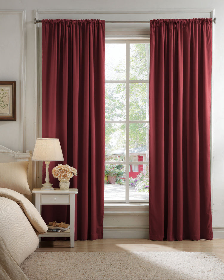 Deep red 100% blackout velvet custom drapery covering a bedroom window, offering privacy and sophisticated light control.