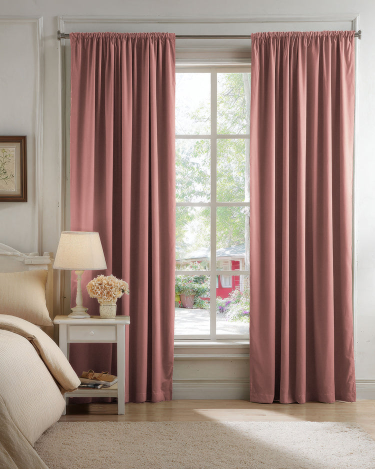 Luxurious blush pink blackout velvet custom drapery covering a bedroom window, showcasing gathered top style for optimal light control.