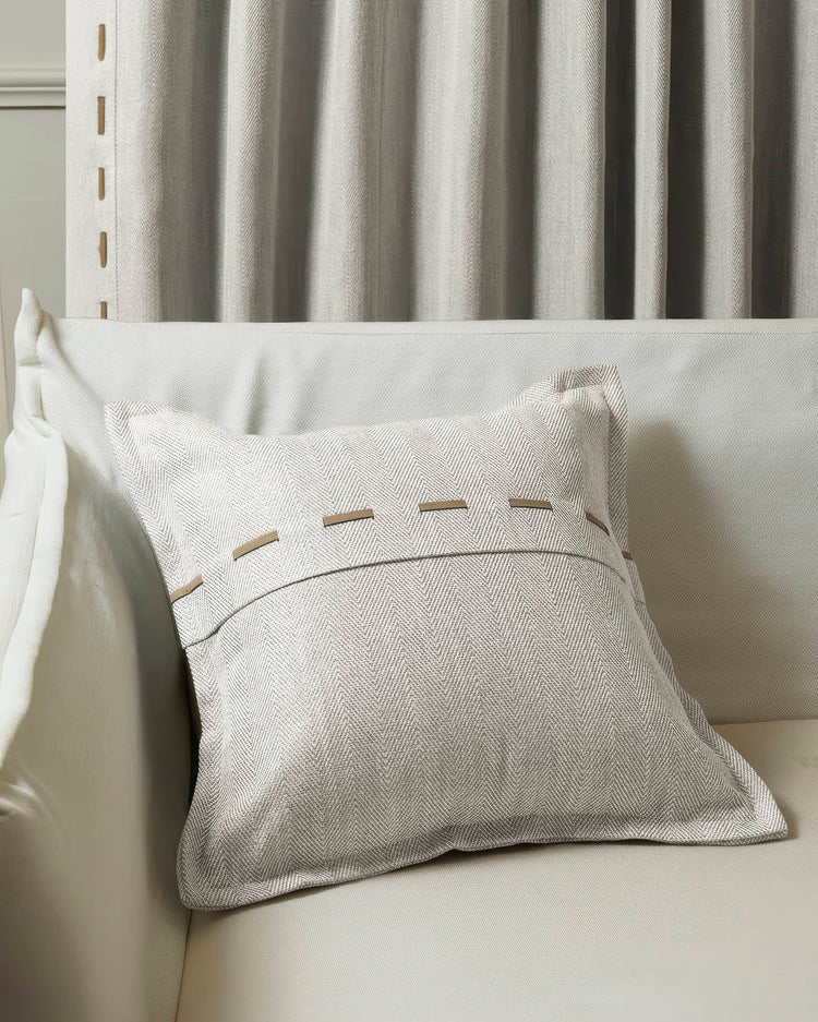 Cleo micro-herringbone throw pillowcase with faux leather lacing on a sofa, paired with custom window treatment drapery.
