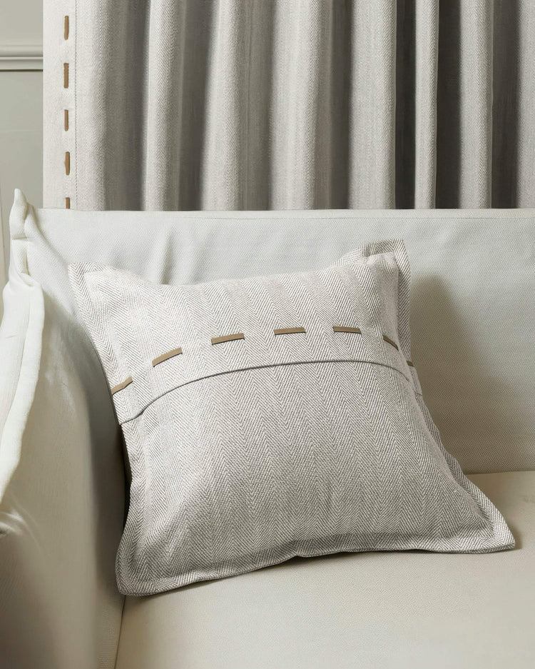 Cleo textured micro-herringbone throw pillowcase with faux leather lacing on a sofa, paired with matching custom drapery.