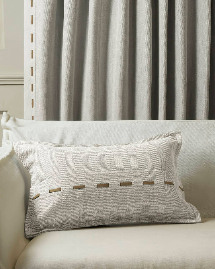 Cleo micro-herringbone textured lumbar pillowcase with faux leather lacing, coordinating with custom drapery for home decor.