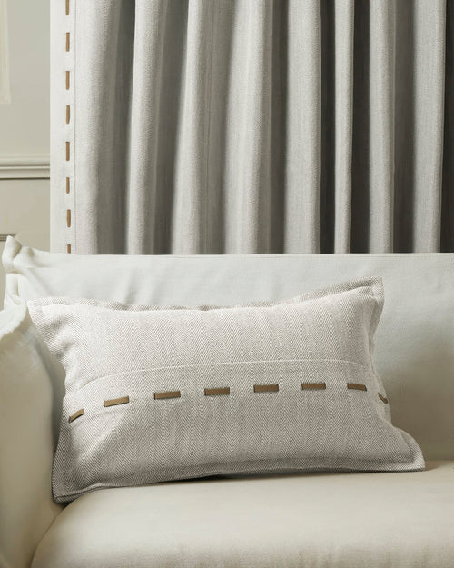 Cleo textured micro-herringbone lumbar pillowcase with faux leather lacing on sofa, coordinating custom drapery.