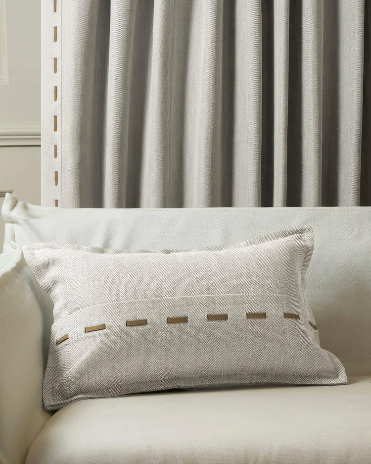 Cleo textured micro-herringbone lumbar pillowcase with faux leather lacing on sofa, coordinating custom drapery.