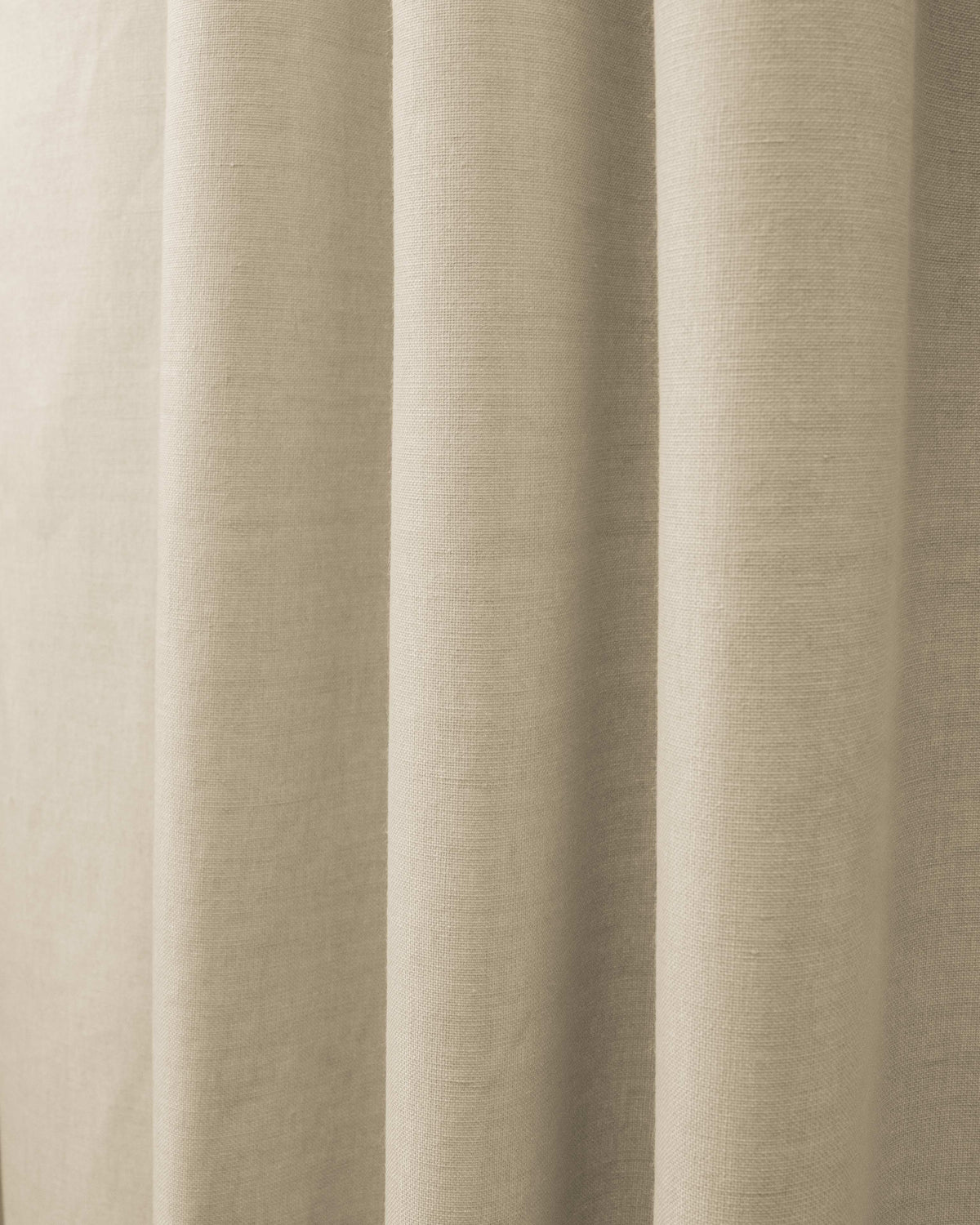 Close-up of Cronin linen look blackout custom curtain fabric in a natural beige, showing textured weave and soft folds.