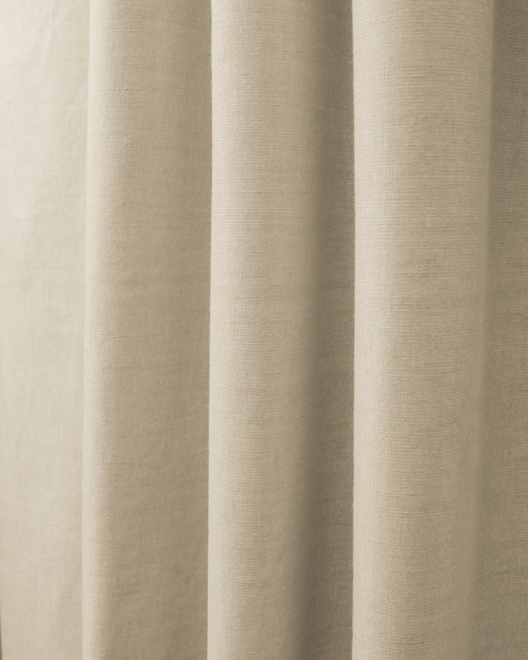 Close-up of Cronin linen look blackout custom curtain fabric in a natural beige, showing textured weave and soft folds.