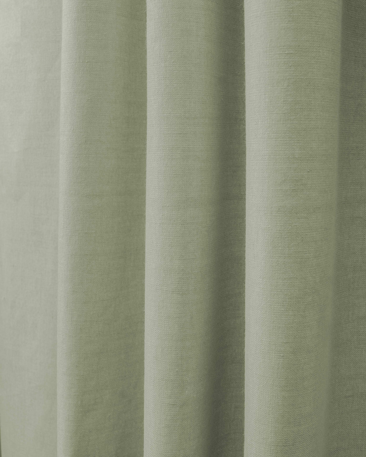 Detailed view of Cronin linen look blackout custom curtain in a soft sage green, showcasing its textured fabric.