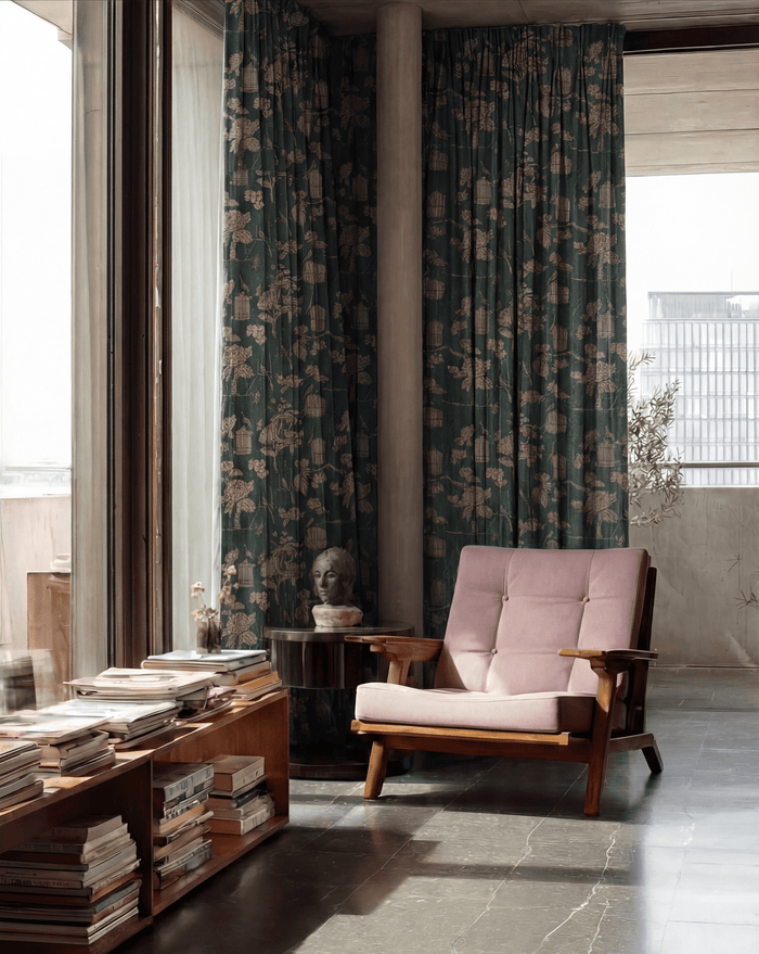 Seeker teal floral linen blend curtains beside a pink armchair, showcasing custom window treatments in a modern room.