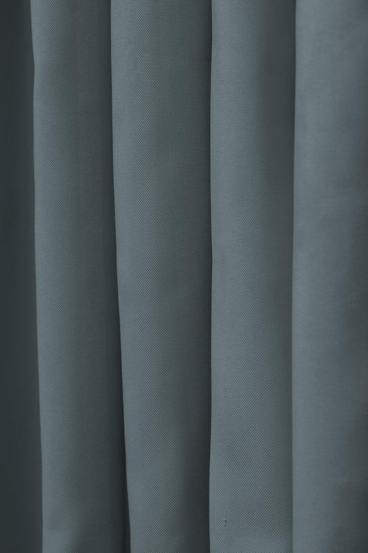 Durable dark grey FadeShield™ canvas custom outdoor curtain, showcasing its waterproof woven texture and elegant folds.